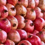 Close-up view of vibrant and ripe pomegranates displaying their organic texture and rich red colors.